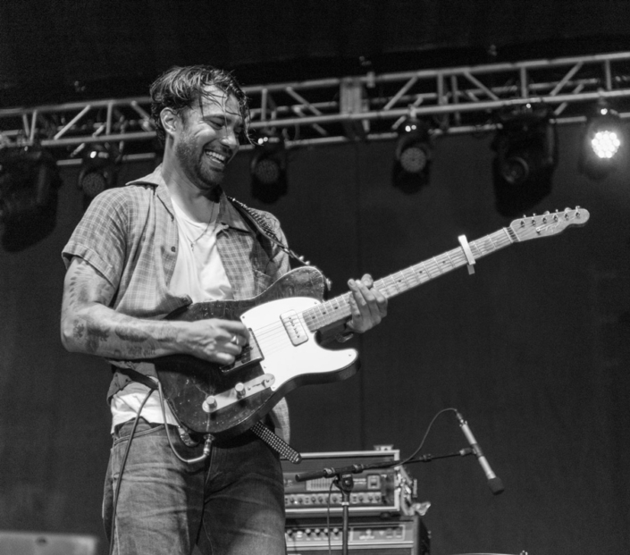 Man playing guitar on a concert stage